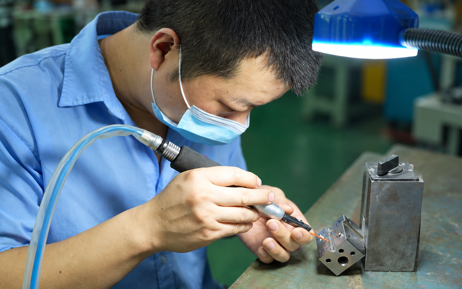 Technician carrying out manual repair work on an injection mold component